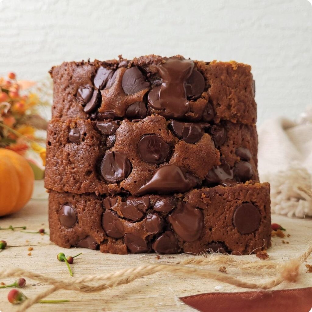 pumpkin chocolate chip bread. side view of a stack of 3 very thick slices. 